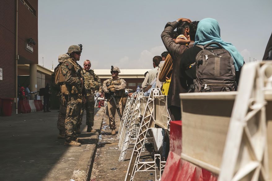 In this image provided by the U.S. Marine Corps, Marines assigned to the 24th Marine Expeditionary Unit (MEU) provide assistance during an evacuation at Hamid Karzai International Airport in Kabul, Afghanistan, Friday, Aug. 20, 2021. (Sgt. Isaiah Campbell/U.S. Marine Corps via AP)