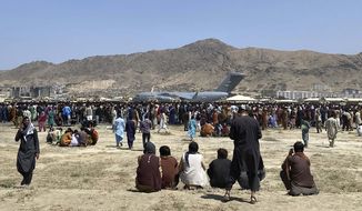 In this Monday, Aug. 16, 2021, file photo hundreds of people gather near a U.S. Air Force C-17 transport plane along the perimeter at the international airport in Kabul, Afghanistan. Hundreds of Western nationals and Afghan workers have been flown to safety since the Taliban reasserted control over the country. Yet still unprotected, and in hiding, are untold numbers of Afghans who tried to build a fledgling democracy. They include Afghans who worked with foreign forces, and who are now stranded and being hunted by the Taliban, along with aid workers. (AP Photo/Shekib Rahmani, File)