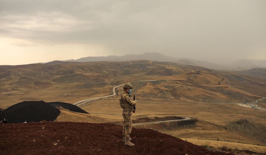 A Turkish soldier stands guard near the wall that separates Turkey and Iran, in Van Province, Turkey, Saturday Aug. 21, 2021. The new border wall separating Turkey from Iran covers a third of the 540-kilometer (335-mile) border, leaving plenty of gaps for migrants to slip across in the dead of night. Traffic on this key migration route from central Asia to Europe has remained relatively stable compared to previous years. But European countries, as well as Turkey, fear the sudden return of Taliban rule in Afghanistan could change that. (AP Photo/Emrah Gurel)