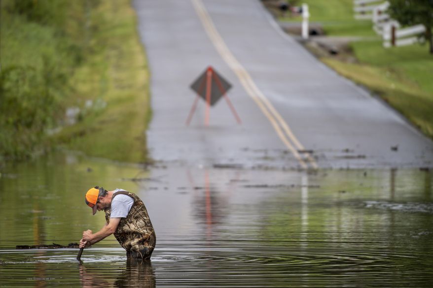 Dickson Public Works personnel check the flooding on Old Pond Lane following heavy rainfall, Saturday, Aug. 21, 2021, in Dickson, Tenn. Heavy flooding in several Middle Tennessee counties on Saturday prompted water rescues, road closures, and communications disruptions, with several people reported missing. Flash flood warnings were in effect for Dickson, Houston and Montgomery and Stewart counties on Saturday evening. (Josie Norris/The Tennessean via AP)