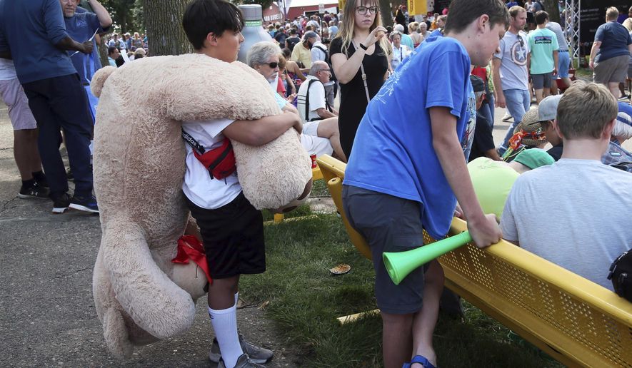 In an Aug. 22, 2019 file photo, a young fair goer carries a stuffed prize bear as the Minnesota State Fair got underway in Falcon Heights, Minn. (AP Photo/Jim Mone,File)