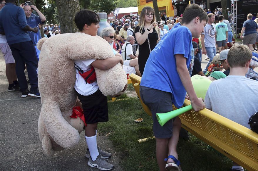 In an Aug. 22, 2019 file photo, a young fair goer carries a stuffed prize bear as the Minnesota State Fair got underway in Falcon Heights, Minn. (AP Photo/Jim Mone,File)