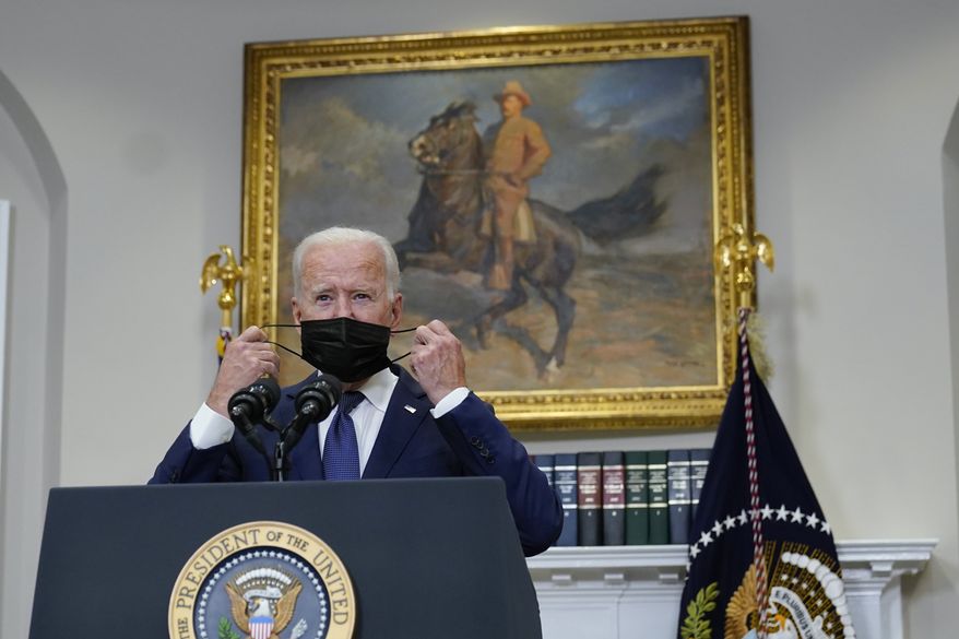 President Joe Biden takes his face mask off before speaking about Afghanistan evacuations in the Roosevelt Room of the White House, Sunday, Aug. 22, 2021, in Washington. (AP Photo/Manuel Balce Ceneta)