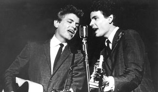 In this July 31, 1964, file photo The Everly Brothers, Phil, left, and Don, perform on stage. Don Everly, one-half of the pioneering rock ‘n’ roll Everly Brothers whose harmonizing country rock hits impacted a generation of rock music, has died.  Don Everly was 84. A family spokesperson said Everly died at his home in Nashville, Tennessee, on Saturday, Aug. 21, 2021. (AP Photo, File)