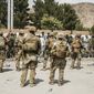 In this Aug. 19, 2021, photo provided by the U.S. Marine Corps, U.S. Soldiers and Marines assist with security at an Evacuation Control Checkpoint during an evacuation at Hamid Karzai International Airport in Kabul, Afghanistan. (Staff Sgt. Victor Mancilla/U.S. Marine Corps via AP)