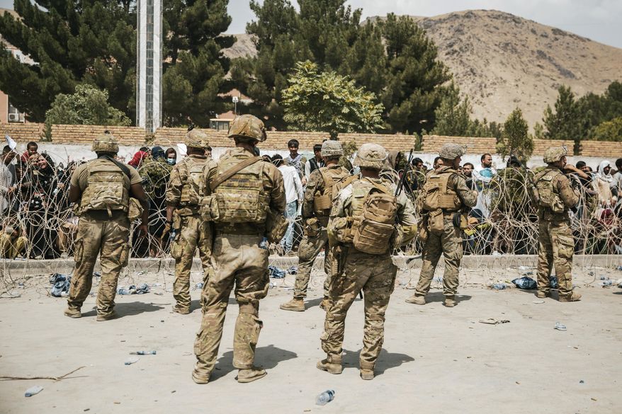 In this Aug. 19, 2021, photo provided by the U.S. Marine Corps, U.S. Soldiers and Marines assist with security at an Evacuation Control Checkpoint during an evacuation at Hamid Karzai International Airport in Kabul, Afghanistan. (Staff Sgt. Victor Mancilla/U.S. Marine Corps via AP)