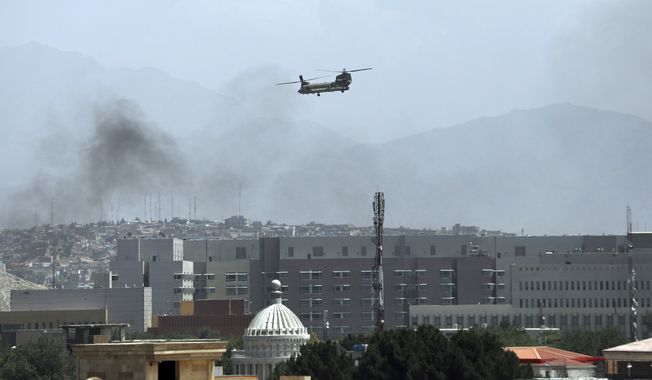 A U.S. Chinook helicopter flies over the city of Kabul, Afghanistan, Sunday, Aug. 15, 2021. Taliban fighters entered the outskirts of the Afghan capital on Sunday, further tightening their grip on the country as panicked workers fled government offices and helicopters landed at the U.S. Embassy. (AP Photo/Rahmat Gul) **FILE**