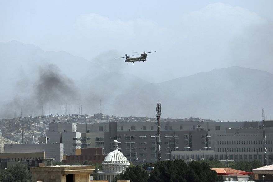 A U.S. Chinook helicopter flies over the city of Kabul, Afghanistan, Sunday, Aug. 15, 2021. Taliban fighters entered the outskirts of the Afghan capital on Sunday, further tightening their grip on the country as panicked workers fled government offices and helicopters landed at the U.S. Embassy. (AP Photo/Rahmat Gul) **FILE**