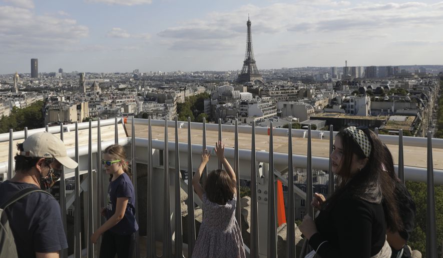 Visitors watch the Eiffel Tower from the top of the Arc de Triomphe, Tuesday, Aug.24, 2021. (AP Photo/Adrienne Surprenant) ** FILE **