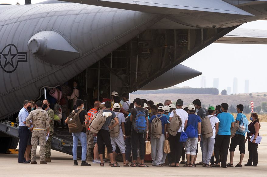 Afghan people who were transported from Afghanistan to Madrid, embark on an U.S. military airplane that will transport them to Germany, at the Torrejon military base as part of the evacuation process in Madrid, Spain, Tuesday, Aug. 24, 2021. (AP Photo/Andrea Comas)
