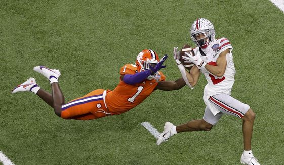 Ohio State wide receiver Chris Olave catches a touchdown pass in front of Clemson cornerback Derion Kendrick during the second half of the Sugar Bowl NCAA college football game in New Orleans, in this Friday, Jan. 1, 2021, file photo. Olave was selected to The Associated Press Preseason All-America first team offense, Monday Aug. 23, 2021. (AP Photo/Butch Dill, File) **FILE**