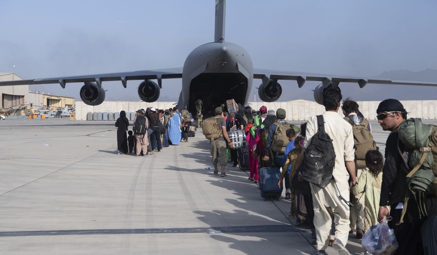 In this image provided by the U.S. Air Force, U.S. Air Force loadmasters and pilots assigned to the 816th Expeditionary Airlift Squadron, load people being evacuated from Afghanistan onto a U.S. Air Force C-17 Globemaster III at Hamid Karzai International Airport in Kabul, Afghanistan, Tuesday, Aug. 24, 2021. (Master Sgt. Donald R. Allen/U.S. Air Force via AP)