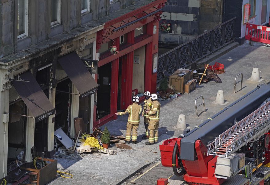Firefighters at the scene after a fire at the Elephant House Cafe in Edinburgh, Wednesday, Aug. 25, 2021. An Edinburgh cafe where author J.K. Rowling wrote some of the Harry Potter books has been damaged in a fire. The Elephant House in the Scottish capital was blackened by a blaze which broke out at the patisserie next door on Tuesday. (Andrew Milligan/PA via AP)