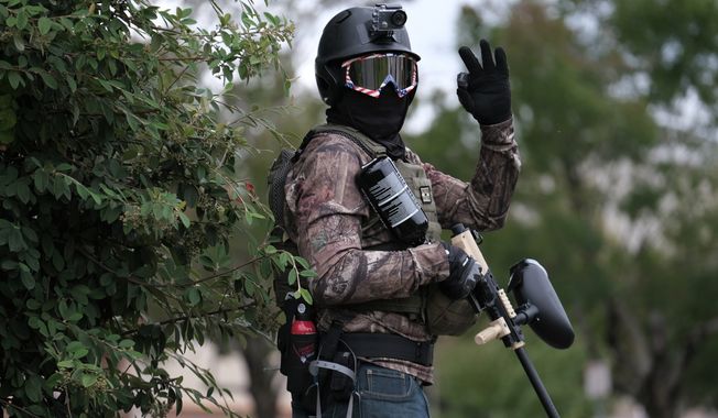 A member of the far-right group Proud Boys flashes an OK sign with their hand as they rally in an abandoned parking lot on the outskirts of town on Sunday, Aug. 22, 2021, in Portland, Ore. (AP Photo/Alex Milan Tracy)