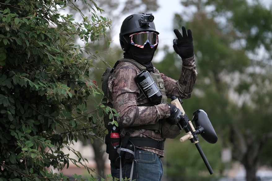A member of the far-right group Proud Boys flashes an OK sign with their hand as they rally in an abandoned parking lot on the outskirts of town on Sunday, Aug. 22, 2021, in Portland, Ore. (AP Photo/Alex Milan Tracy)