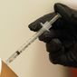 A woman is injected with her second dose of the Pfizer COVID-19 vaccine at a Dallas County Health and Human Services vaccination site in Dallas, Thursday, Aug. 26, 2021. (AP Photo/LM Otero)