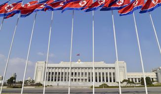 FILE - In this April 9, 2020, file photo, North Korean flags flutter in front of the Presidium of the Supreme People&#39;s Assembly building in Pyongyang, North Korea. North Korea will convene its rubber-stamp parliament on Sept. 28, 2021 to discuss efforts to salvage an economy strained by pandemic border closures after decades of mismanagement and U.S.-led sanctions. (Kyodo News via AP, File)
