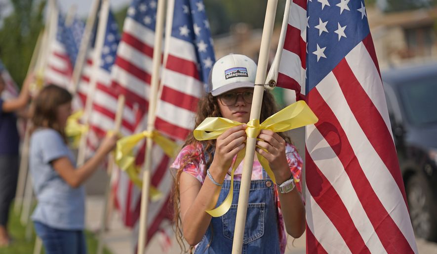 Neighbors tie yellow ribbons to flags in front of the family&#39;s home of U.S. Marines Staff Sgt. Taylor Hoover Friday, Aug. 27, 2021, in Sandy, Utah. Hoover was among the 13 U.S. troops killed in a horrific suicide bombing at Afghanistan&#39;s Kabul airport, which also claimed the lives of more than 100 Afghans. Hoover had been in the Marines for 11 years, his father Darin Hoover said Friday. (AP Photo/Rick Bowmer) **FILE**