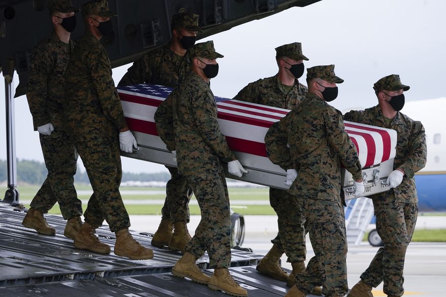 A Marine Corps carry team moves a transfer case containing the remains of Marine Marine Corps Sgt. Johanny Rosario Pichardo, 25, of Lawrence, Mass., Sunday, Aug. 29, 2021, at Dover Air Force Base, Del. President Joe Biden embarked on a solemn journey Sunday to honor and mourn the 13 U.S. troops killed in the suicide attack near the Kabul airport as their remains return to U.S. soil from Afghanistan. (AP Photo/Manuel Balce Ceneta)