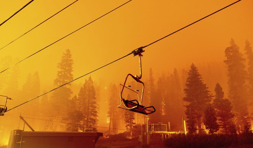 Seen in a long camera exposure, the Caldor Fire burns as a chair lift sits at the Sierra-at-Tahoe ski resort on Sunday, Aug. 29, 2021, in Eldorado National Forest, Calif. The main buildings at the ski slope&#x27;s base survived as the main fire front passed. (AP Photo/Noah Berger)