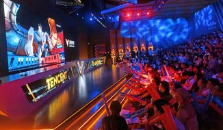 Fans watch the match of the 2020 League of Legends World Championship televised on a screen at a Tencent V-station in Shanghai, China, Oct. 31, 2020. Hugely popular online games and celebrity culture are the latest targets in the ruling Communist Party&#39;s campaign to encourage China&#39;s public to align their lives with its political and economic goals. (Chinatopix Via AP)