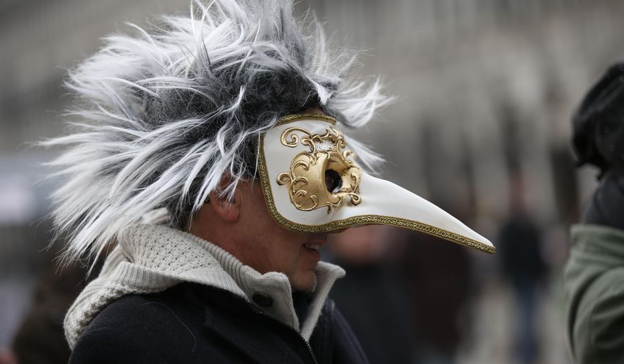 FILE - In this Jan. 24, 2016 file photo, a man wears a pest doctor mask in St. Mark&#x27;s Square in Venice, Italy. This carnival mask derives from 16th century doctors wearing beak-nosed masks filled with aromatic herbs to cleanse the air they breathed when treating the sick. Venice’s central place in the history of battling pandemics and pestilence will come into focus at this year’s Venice Film Festival, which opens Wednesday, Sept. 1, 2021, with the premiere of Pedro Almodovar’s in-competition “Madres Paralelas” (Parallel Mothers), which he developed during Spain’s 2020 coronavirus lockdown, one of the harshest in the West. (AP Photo/Luca Bruno)