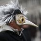 FILE - In this Jan. 24, 2016 file photo, a man wears a pest doctor mask in St. Mark&#39;s Square in Venice, Italy. This carnival mask derives from 16th century doctors wearing beak-nosed masks filled with aromatic herbs to cleanse the air they breathed when treating the sick. Venice’s central place in the history of battling pandemics and pestilence will come into focus at this year’s Venice Film Festival, which opens Wednesday, Sept. 1, 2021, with the premiere of Pedro Almodovar’s in-competition “Madres Paralelas” (Parallel Mothers), which he developed during Spain’s 2020 coronavirus lockdown, one of the harshest in the West. (AP Photo/Luca Bruno)