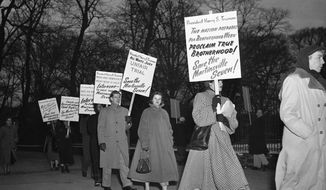 In this Jan. 30, 1951, file photo, as temperatures drop below freezing, demonstrators march in front of the White House in Washington, in what they said was an effort to persuade President Harry Truman to halt the execution of seven Black men sentenced to death in Virginia on charges of raping a white woman. Virginia Gov. Ralph Northam granted posthumous pardons Tuesday, Aug. 31, 2021, to seven Black men who were executed in 1951 for the rape of a white woman, in a case that attracted pleas for mercy from around the world and in recent years has been denounced as an example of racial disparity in the use of the death penalty. (AP Photo/Henry Burroughs, File)