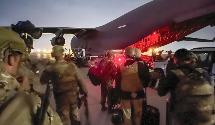 In this image provided by the U.S. Army, paratroopers assigned to the 82nd Airborne Division, and others, prepare to board a C-17 cargo plane at Hamid Karzai International Airport in Kabul, Afghanistan, Monday, Aug. 30, 2021. (Master Sgt. Alexander Burnett/U.S. Army via AP)