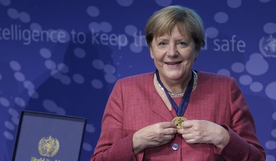German Chancellor Angela Merkel, right, smiles after she received a medal by Tedros Adhanom Ghebreyesus, left, director-general of the World Health Organization (WHO), during the inauguration ceremony of the &#x27;WHO Hub For Pandemic And Epidemic Intelligence&quot; at the Langenbeck-Virchow building in Berlin, Germany, Wednesday, Sept. 1, 2021. (AP Photo/Michael Sohn, pool)
