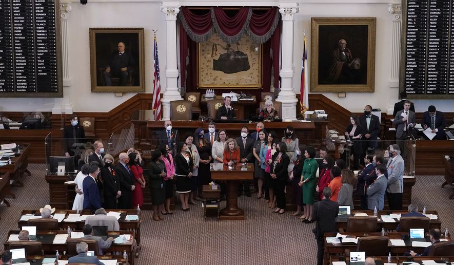 In this May 5, 2021, file photo, Texas state Rep. Donna Howard, D-Austin, center at the lectern, stands with fellow lawmakers in the House Chamber in Austin, Texas, as she opposes a bill introduced that would ban abortions as early as six weeks and allow private citizens to enforce it through civil lawsuits, under a measure given preliminary approval by the Republican-dominated House. A Texas law banning most abortions in the state took effect at midnight on Sept. 1, but the Supreme Court has yet to act on an emergency appeal to put the law on hold. (AP Photo/Eric Gay, File)