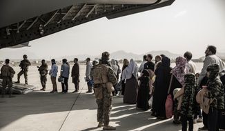 In this image provided by the U.S. Marine Corps, evacuees wait to board a Boeing C-17 Globemaster III during an evacuation at Hamid Karzai International Airport in Kabul, Afghanistan, Monday, Aug. 30. 2021. (Staff Sgt. Victor Mancilla/U.S. Marine Corps via AP) ** FILE **