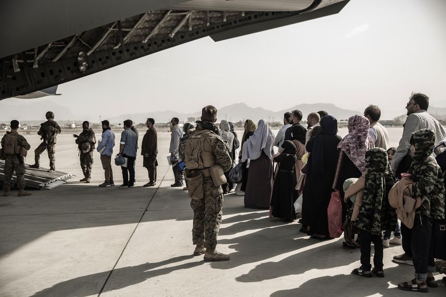 In this image provided by the U.S. Marine Corps, evacuees wait to board a Boeing C-17 Globemaster III during an evacuation at Hamid Karzai International Airport in Kabul, Afghanistan, Monday, Aug. 30. 2021. (Staff Sgt. Victor Mancilla/U.S. Marine Corps via AP) ** FILE **