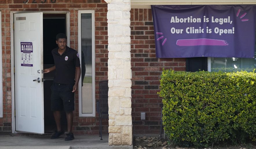 In this Sept. 1, 2021 file photo, a security guard opens the door to the Whole Women&#x27;s Health Clinic in Fort Worth, Texas.  (AP Photo/LM Otero)  **FILE**