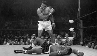 Heavyweight champion Muhammad Ali stands over fallen challenger Sonny Liston, shouting and gesturing shortly after dropping Liston with a short hard right to the jaw on May 25, 1965, in Lewiston, Maine. (AP Photo/John Rooney, File)