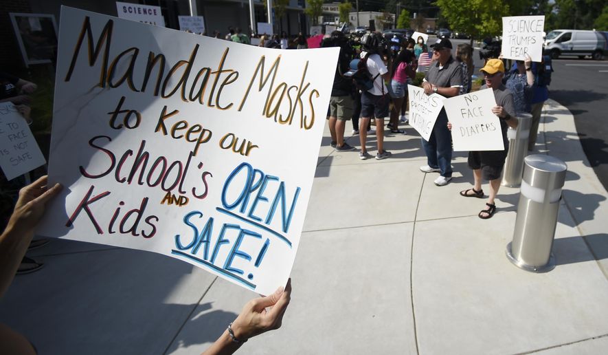 In this Aug. 12, 2021, file photo, pro-mask and non-mask wearing demonstrators face off at the Cobb County School Board Headquarters in Marietta, Ga. The start of school year has also led to fierce battles between parents and administrators over mask requirements that have devolved into violence at times. In the state of Georgia, many school superintendents said they experienced more cases and quarantines in the first few weeks of class than during all of last year. (AP Photo/Mike Stewart, File)  **FILE**