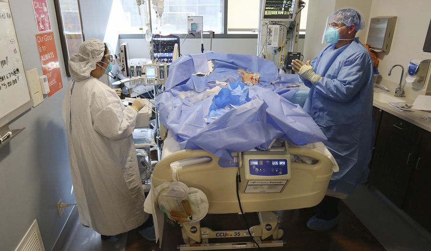 In this Dec. 29, 2020, file photo, Memorial Hospital registered nurse Steve Menchaca, right, and Emily Rentquiano tend to a patient in the COVID-19 intensive care unit in Bakersfield, Calif. (Alex Horvath/The Bakersfield Californian via AP) ** FILE **