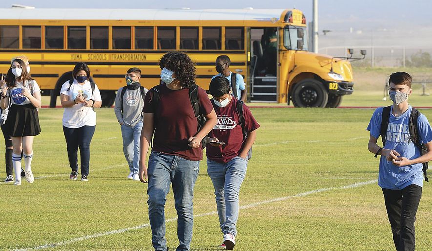 In this Sept. 17, 2020, file photo, students in face masks arrive on the Gila Ridge High School campus on the second first day of school, in Yuma, Ariz. (Randy Hoeft/The Yuma Sun via AP) ** FILE **