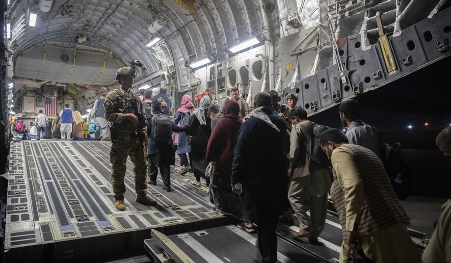 In this Aug. 22, 2021, file photo provided by the U.S. Air Force, Afghan passengers board a U.S. Air Force C-17 Globemaster III during the Afghanistan evacuation at Hamid Karzai International Airport in Kabul, Afghanistan. (MSgt. Donald R. Allen/U.S. Air Force via AP, File)
