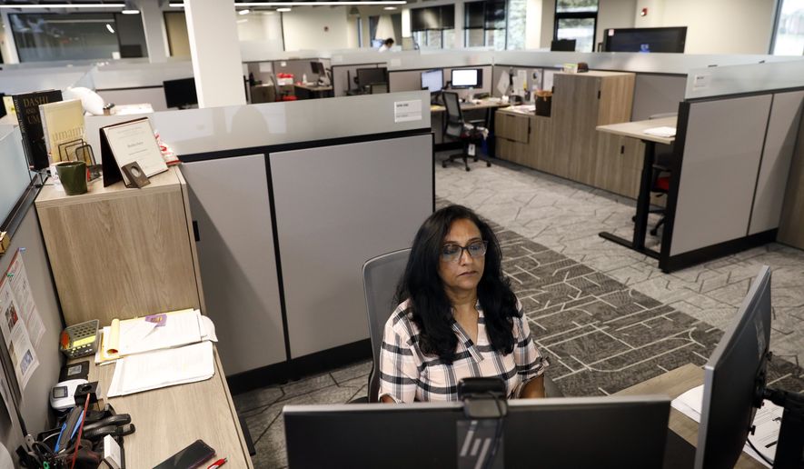 Shobha Surya, associate manager for projects and sales operations of Ajinomoto, a global food and pharmaceutical company, works in a shared office space in Itasca, Ill., Monday, June 7, 2021. Surya said she feels energized by the light pouring in from skylights at the new headquarters, adding that she missed her colleagues and is thrilled to be back in-person. (AP Photo/Shafkat Anowar)