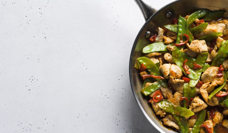 This image released by Milk Street shows a recipe for stir-fried chicken and snow peas. This recipe, with just six ingredients, was inspired by the popular Malaysian dish ayam paprik. (Milk Street via AP)
