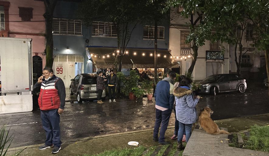 People gather outside on the sidewalk after a strong earthquake was felt, in the Roma neighborhood of Mexico City, Tuesday, Sept. 7, 2021. The quake struck southern Mexico near the resort of Acapulco, causing buildings to rock and sway in Mexico City nearly 200 miles away (AP Photo/Leslie Mazoch)