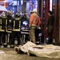 In this Nov. 13, 2015, file photo, medics stand by victims in a Paris restaurant, Friday, Nov. 13, 2015. On Nov. 13, 2015, a cell of nine Islamic State militants armed with automatic rifles and explosive vests left a trail of dead and injured at the national stadium, Paris bars and restaurants and the Bataclan concert hall. Nearly all the attackers were from France or Belgium, as were the cell&#39;s 10th member — the only one still alive. He is the chief defendant among 20 people charged in a trial that is expected to last nine months. (AP Photo/Thibault Camus, File)