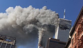 In this Sept. 11, 2001 photo, smoke rises from the burning twin towers of the World Trade Center after hijacked planes crashed into them, in New York City. (AP Photo/Richard Drew, File)