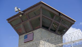 In this June 17, 2019, file photo reviewed by U.S. military officials, an American flag is displayed on the control tower of the Camp VI detention facility in Guantanamo Bay Naval Base, Cuba. The White House says it intends to shutter the prison on the U.S. base in Cuba, which opened in January 2002 and where most of the 39 men still held have never been charged with a crime. (AP Photo/Alex Brandon, File)