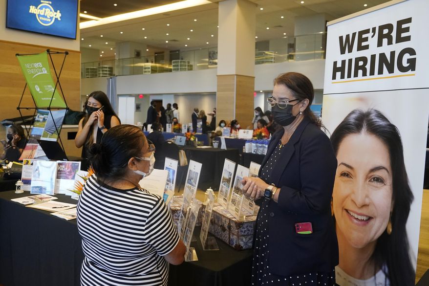 Marriott human resources recruiter Mariela Cuevas, left, talks to Lisbet Oliveros, during a job fair at Hard Rock Stadium, Friday, Sept. 3, 2021, in Miami Gardens, Fla. The number of Americans seeking unemployment benefits fell sharply last week to 310,000, a pandemic low and a sign that the surge in COVID-19 cases caused by the delta variant has yet to lead to widespread layoffs. (AP Photo/Marta Lavandier)