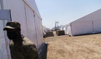 A soldier stands outside tents at Fort Bliss&#39; Doña Ana Village where Afghan refugees are being housed in Chaparral, N.M., Friday, Sept. 10, 2021. The Biden administration provided the first public look inside the U.S. military base where Afghans airlifted out of Afghanistan are screened, amid questions about how the government is caring for the refugees and vetting them. (AP Photo/David Goldman)