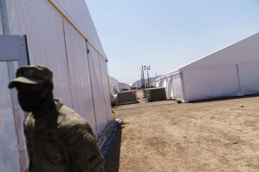 A soldier stands outside tents at Fort Bliss&#39; Doña Ana Village where Afghan refugees are being housed in Chaparral, N.M., Friday, Sept. 10, 2021. The Biden administration provided the first public look inside the U.S. military base where Afghans airlifted out of Afghanistan are screened, amid questions about how the government is caring for the refugees and vetting them. (AP Photo/David Goldman)
