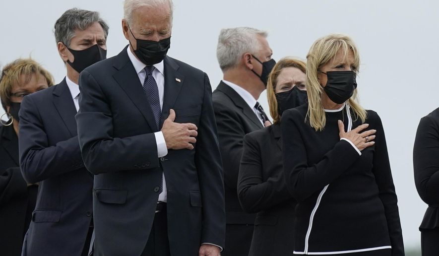 President Joe Biden and first lady Jill Biden watch as a carry team moves the transfer case containing the remains of Navy Corpsman Maxton W. Soviak, 22, of Berlin Heights, Ohio, during a casualty return Sunday, Aug. 29, 2021, at Dover Air Force Base, Del. According to the Department of Defense, Soviak died in an attack at Afghanistan&#x27;s Kabul airport, along with 12 other U.S. service members. (AP Photo/Carolyn Kaster)
