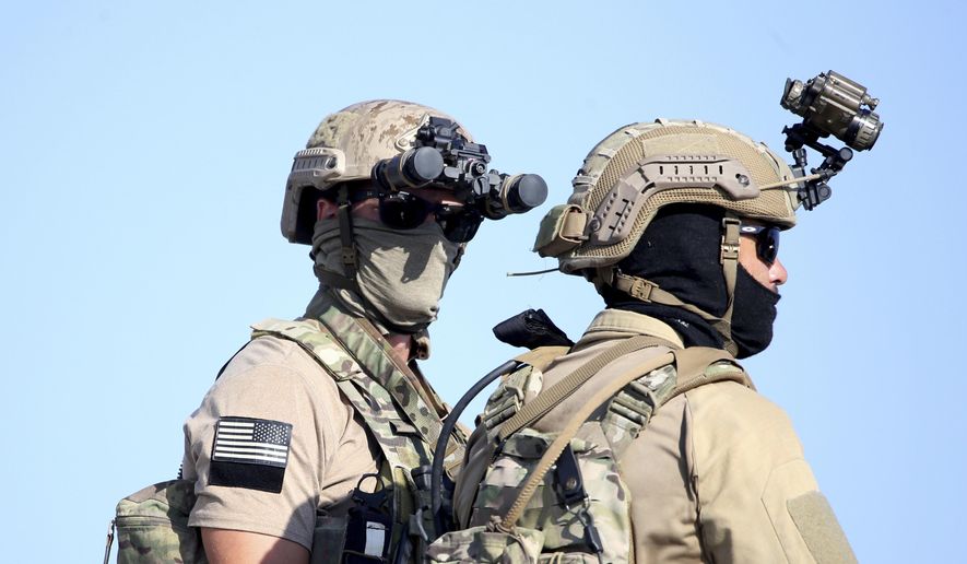 A U.S. Navy SEAL special forces operator, left, stands with a colleague during a joint U.S.-Cyprus military drill at Limassol port on Friday, Sept. 10, 2021. President Biden on Monday honored two Navy Seals (not pictured) declared dead after they went missing more than ten days ago during an operation to stop Iranian weapons from falling into the hands of Houthi rebels. (AP Photo/Philippos Christou)